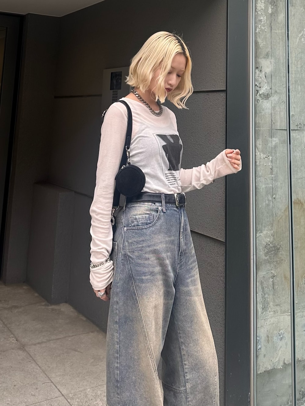 ホワイト系のTシャツ/カットソー、ブラック系のショルダーバッグ、ブルー系のデニムパンツを着用したレディースの春コーディネートの5枚目の写真