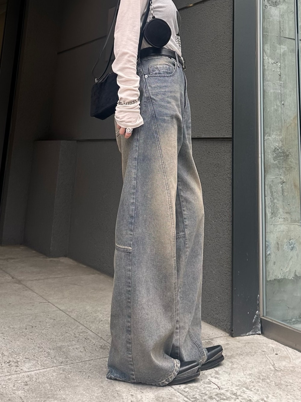 ホワイト系のTシャツ/カットソー、ブラック系のショルダーバッグ、ブルー系のデニムパンツを着用したレディースの春コーディネートの8枚目の写真