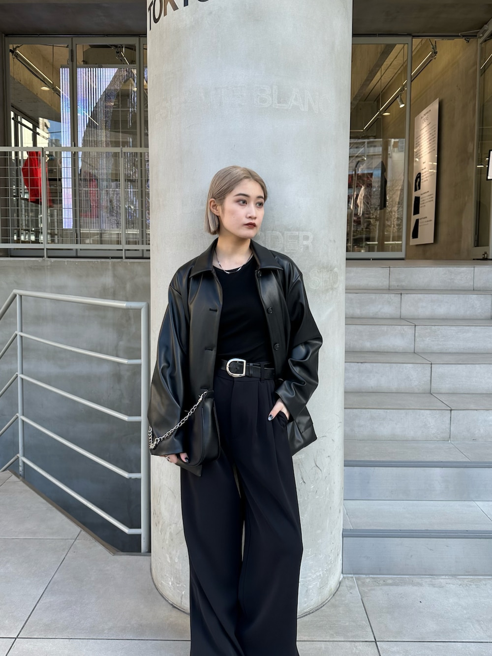 ブラック系のカバーオール、ブラック系のパンツ、ブラック系のショルダーバッグを着用したレディースの春コーディネートの5枚目の写真