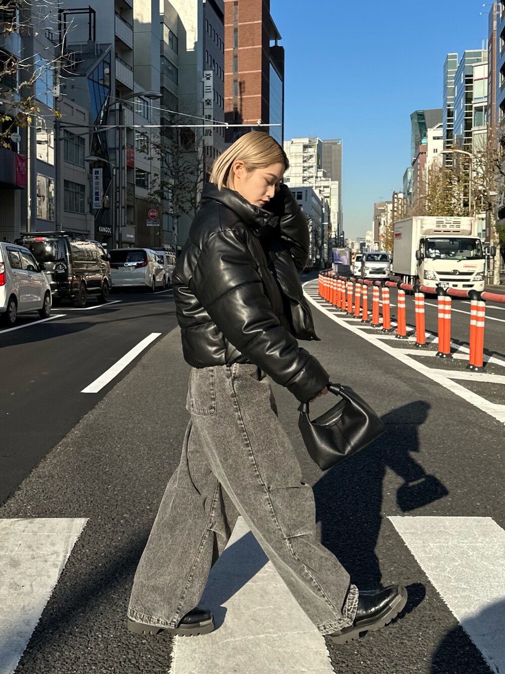 ブラック系のショルダーバッグ、ブラック系のデニムパンツを着用したレディースの冬コーディネートの4枚目の写真