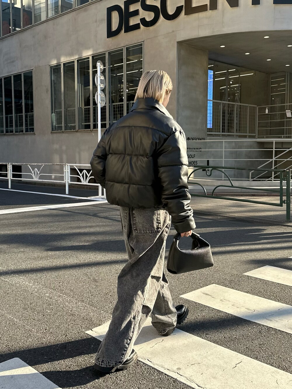 ブラック系のショルダーバッグ、ブラック系のデニムパンツを着用したレディースの冬コーディネートの5枚目の写真