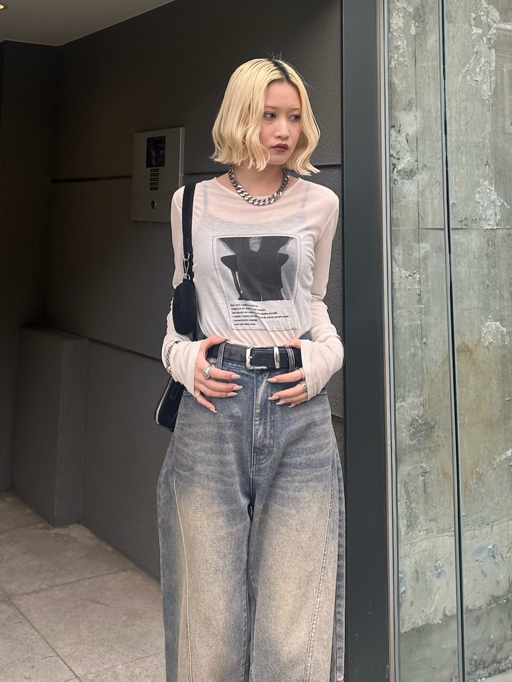 ホワイト系のTシャツ/カットソー、ブラック系のショルダーバッグ、ブルー系のデニムパンツを着用したレディースの春コーディネートの4枚目の写真