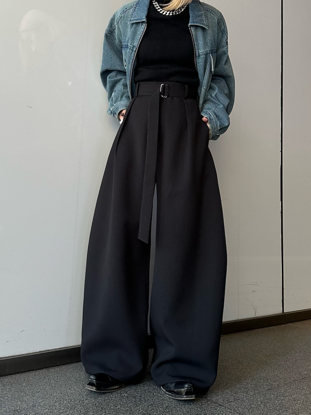 ブルー系のデニムジャケット、ブラック系のニット/セーター、ブラック系のスラックスを着用したレディースの冬コーディネートの6枚目の写真