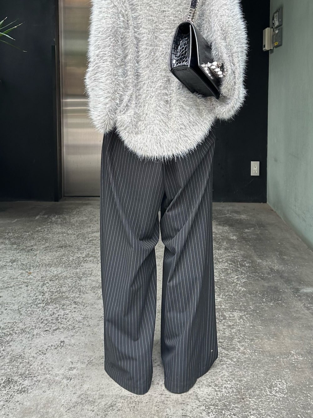 グレー系のニット/セーター、ブラック系のその他パンツ、シルバー系のネックレスを着用したレディースの秋コーディネートの10枚目の写真