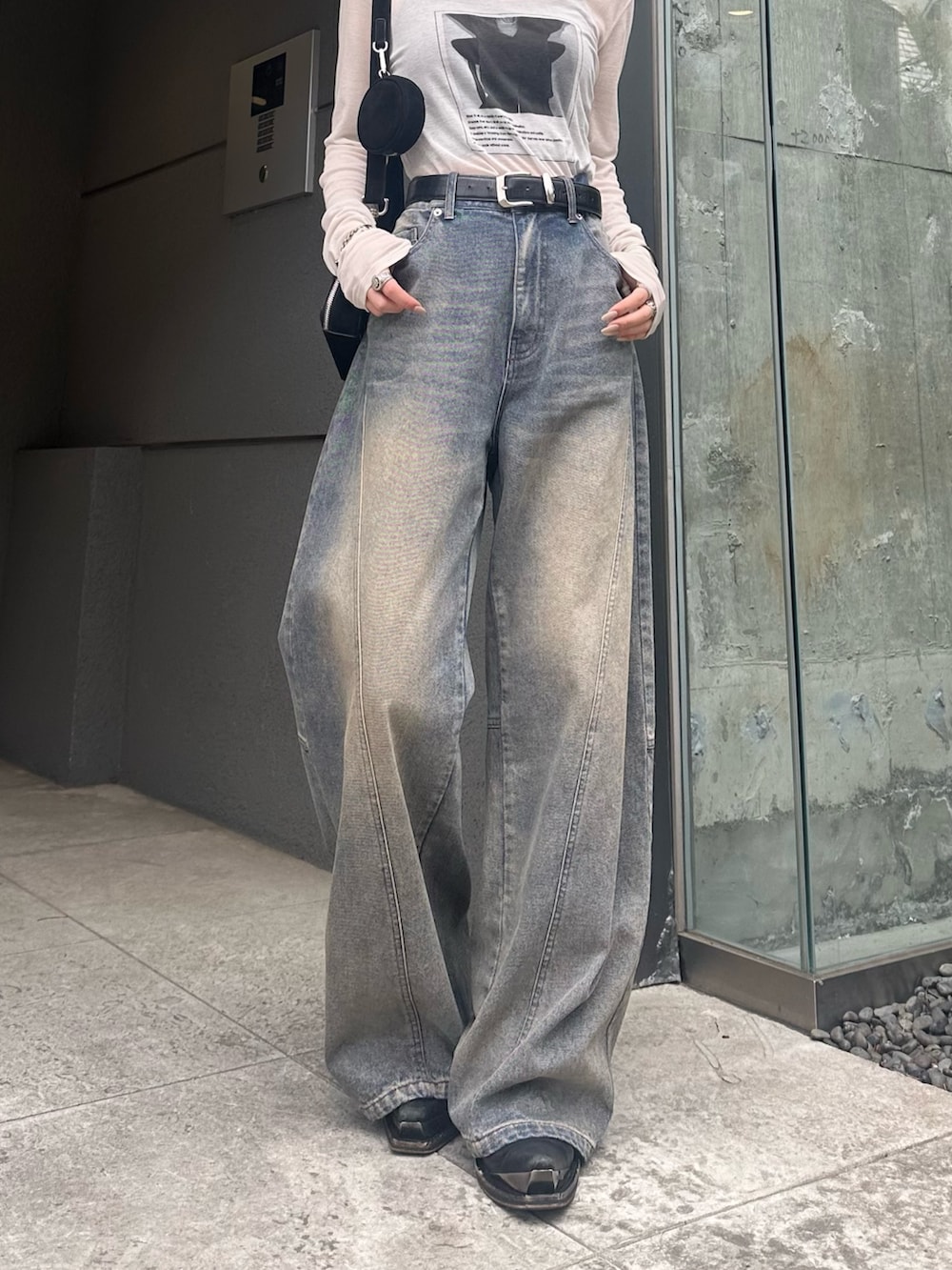 ホワイト系のTシャツ/カットソー、ブラック系のショルダーバッグ、ブルー系のデニムパンツを着用したレディースの春コーディネートの7枚目の写真