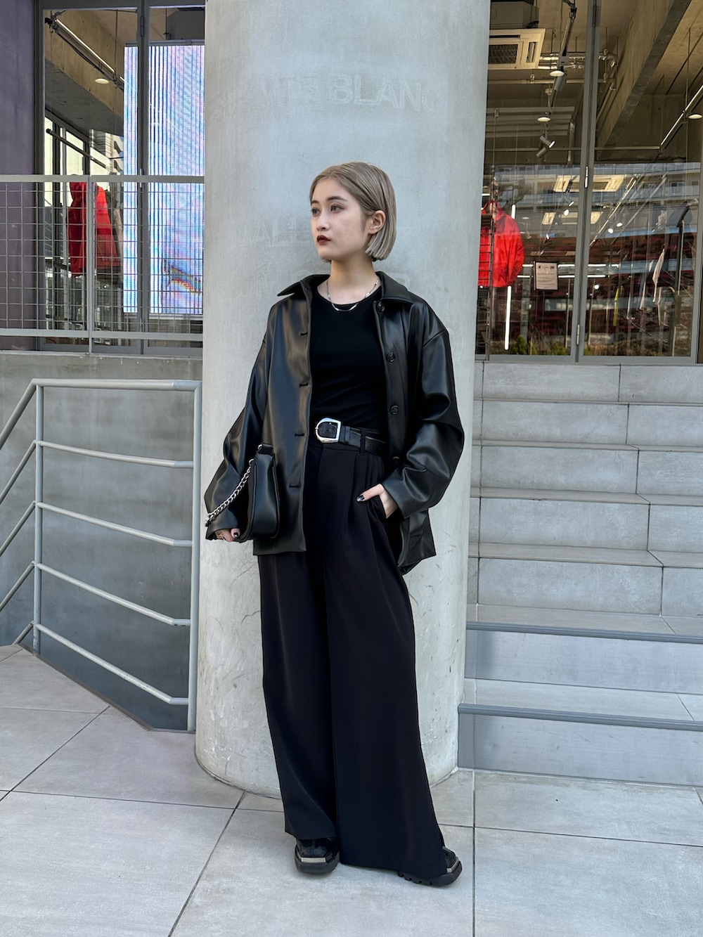 ブラック系のカバーオール、ブラック系のパンツ、ブラック系のショルダーバッグを着用したレディースの春コーディネートの3枚目の写真