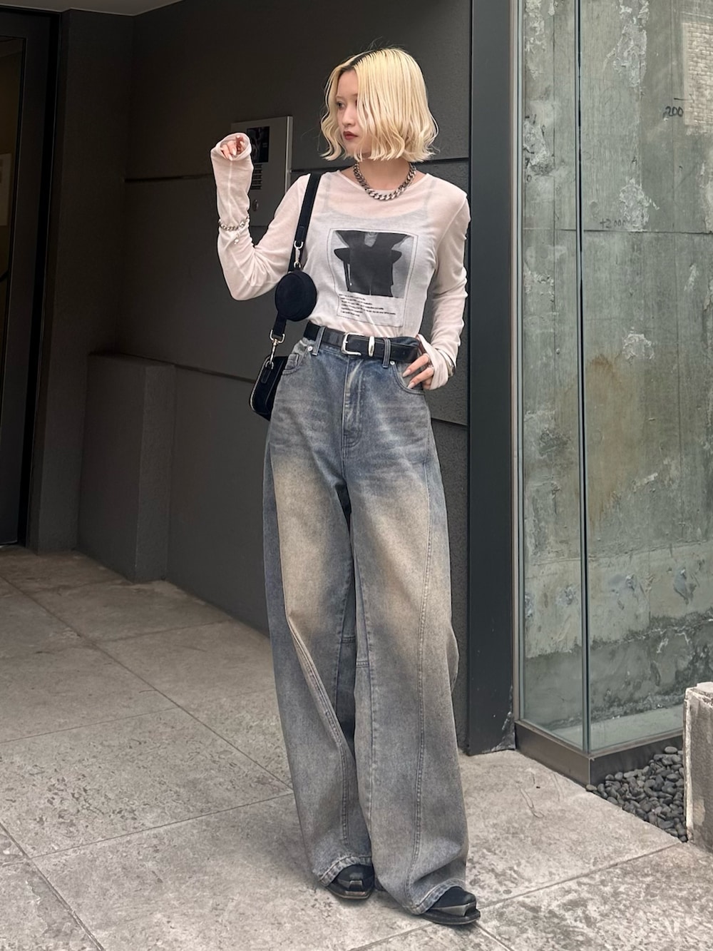 ホワイト系のTシャツ/カットソー、ブラック系のショルダーバッグ、ブルー系のデニムパンツを着用したレディースの春コーディネートの2枚目の写真