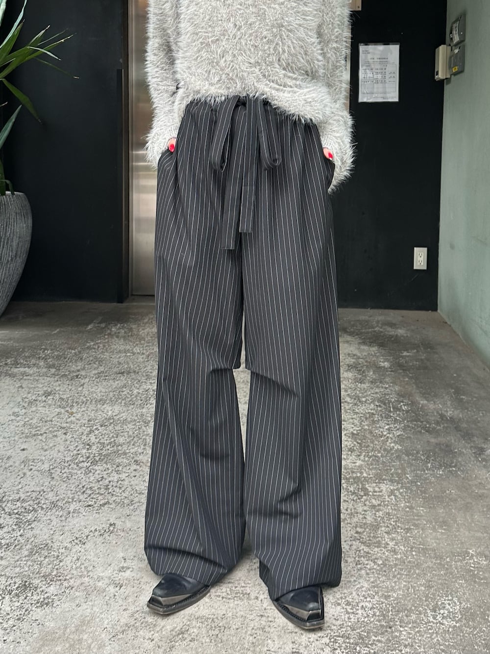 グレー系のニット/セーター、ブラック系のその他パンツ、シルバー系のネックレスを着用したレディースの秋コーディネートの8枚目の写真