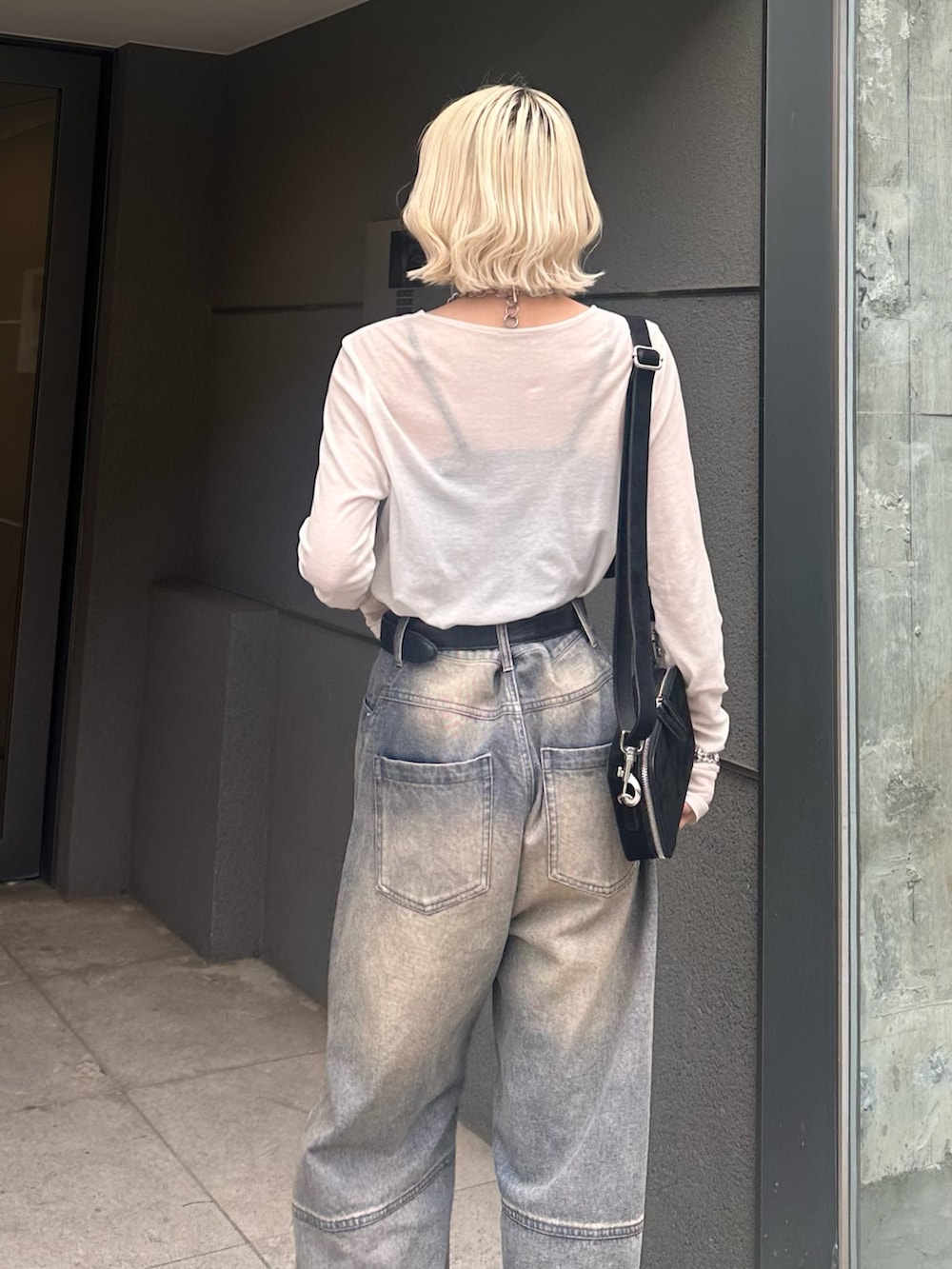 ホワイト系のTシャツ/カットソー、ブラック系のショルダーバッグ、ブルー系のデニムパンツを着用したレディースの春コーディネートの6枚目の写真