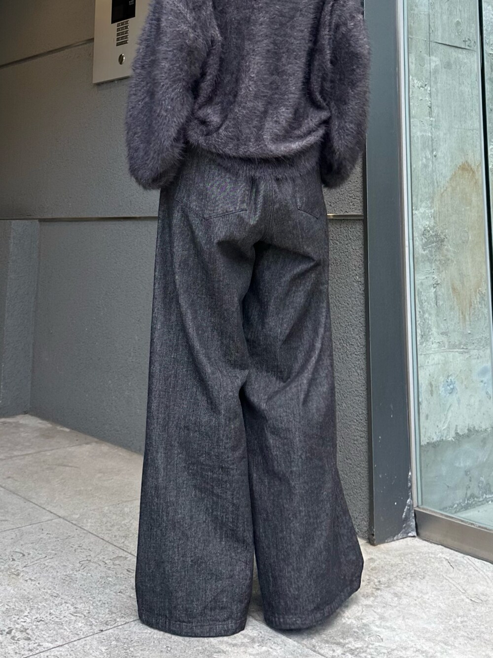 ブラック系のニット/セーター、ブラック系のデニムパンツ、シルバー系のネックレスを着用したレディースの秋コーディネートの9枚目の写真