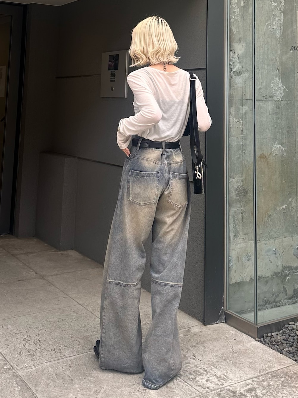 ホワイト系のTシャツ/カットソー、ブラック系のショルダーバッグ、ブルー系のデニムパンツを着用したレディースの春コーディネートの3枚目の写真