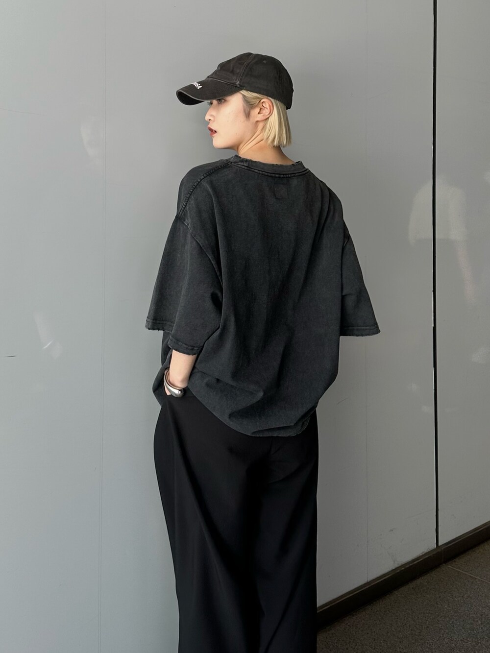 ブラック系のTシャツ/カットソー、ブラック系のスラックスを着用したレディースの春コーディネートの6枚目の写真