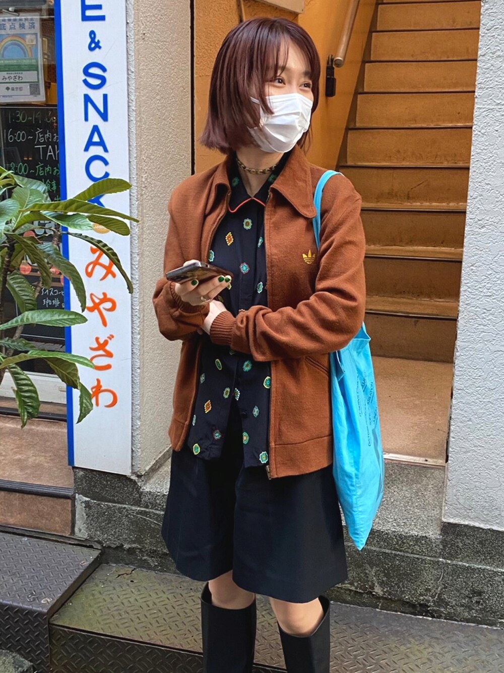 ブラウン系のシャツ/ブラウス、ブルー系のトートバッグ、ブルー系のニットキャップ/ビーニーを着用したレディースの冬コーディネートの2枚目の写真