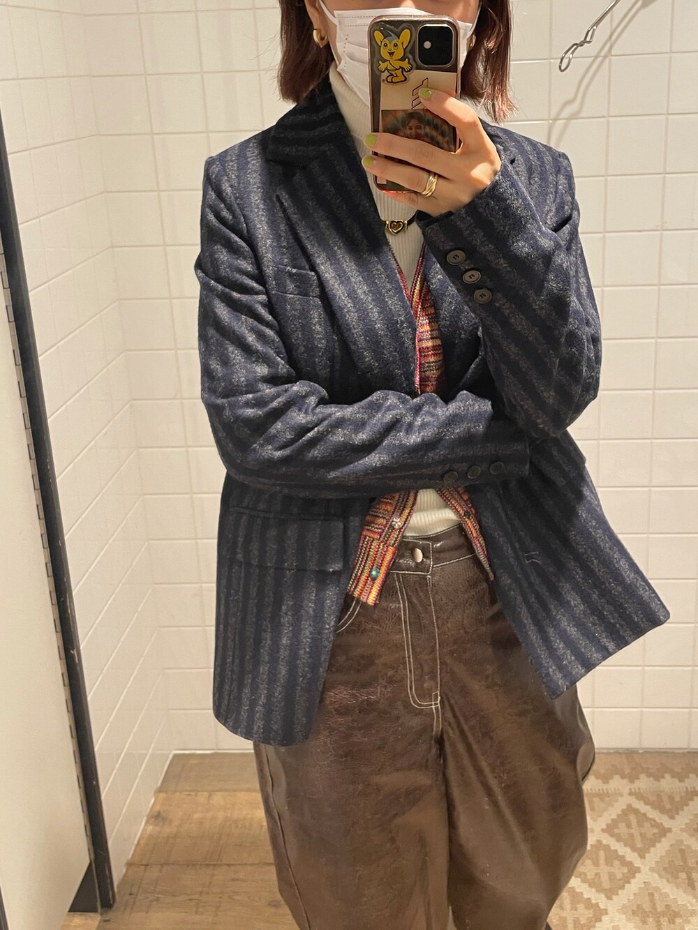 レッド系のベスト、ブラウン系のパンツを着用したレディースの冬コーディネートの2枚目の写真