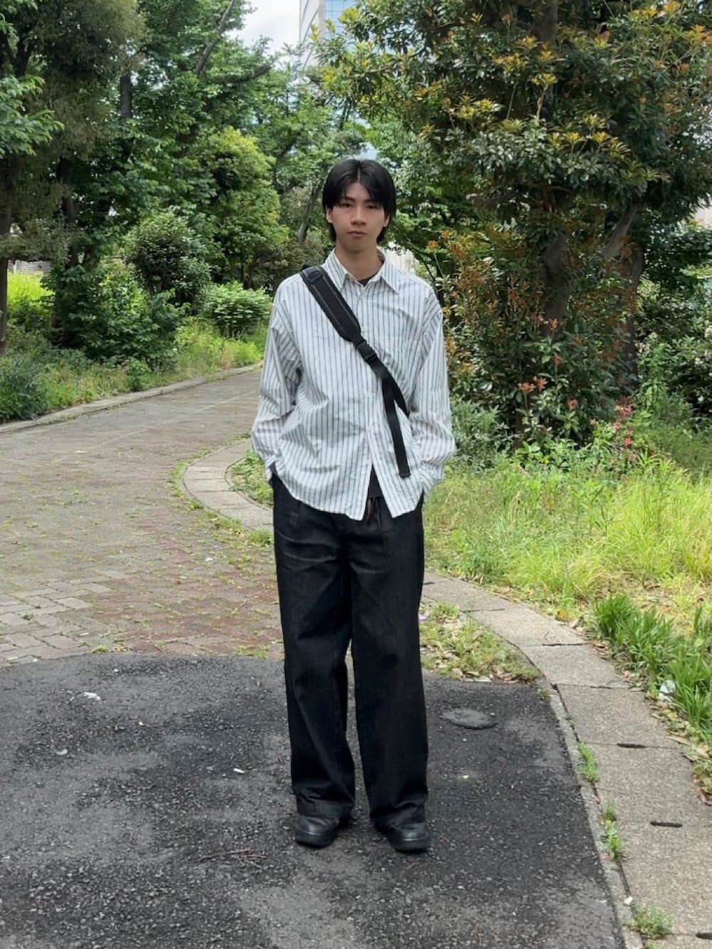 ブルー系のシャツ/ブラウス、ブラック系のデニムパンツ、ブラック系のスニーカーを着用したメンズの春コーディネートの2枚目の写真