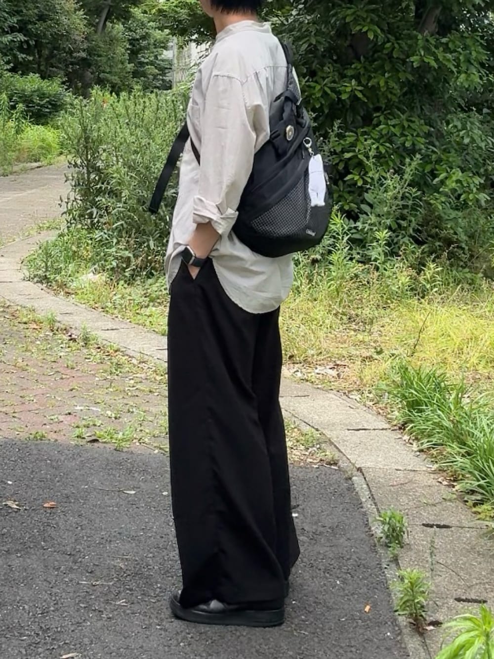 ベージュ系のシャツ/ブラウス、ブラック系のスラックス、ブラック系のスニーカーを着用したメンズの夏コーディネートの2枚目の写真