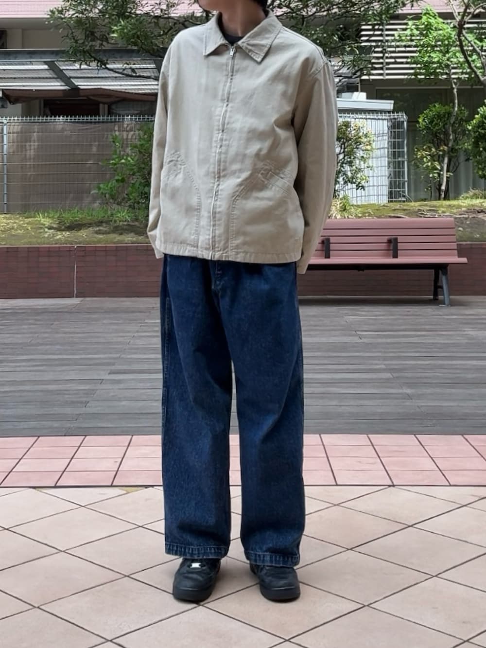 ベージュ系のブルゾン、ブルー系のデニムパンツ、ブラック系のスニーカーを着用したメンズの春コーディネートの2枚目の写真