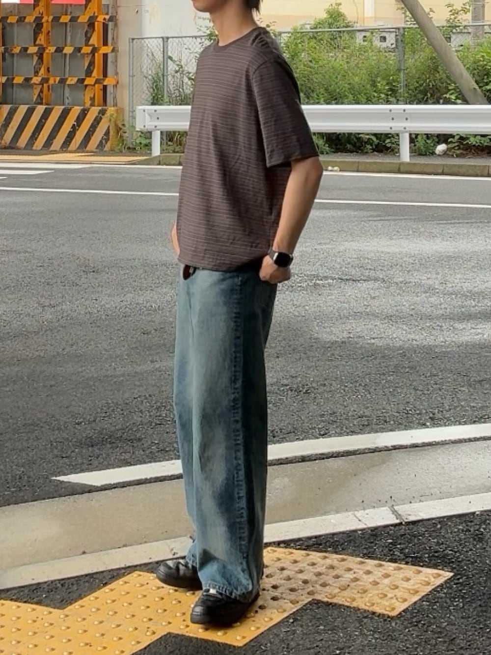 グレー系のTシャツ/カットソー、ブルー系のデニムパンツ、ブラック系のスニーカーを着用したメンズの夏コーディネートの2枚目の写真