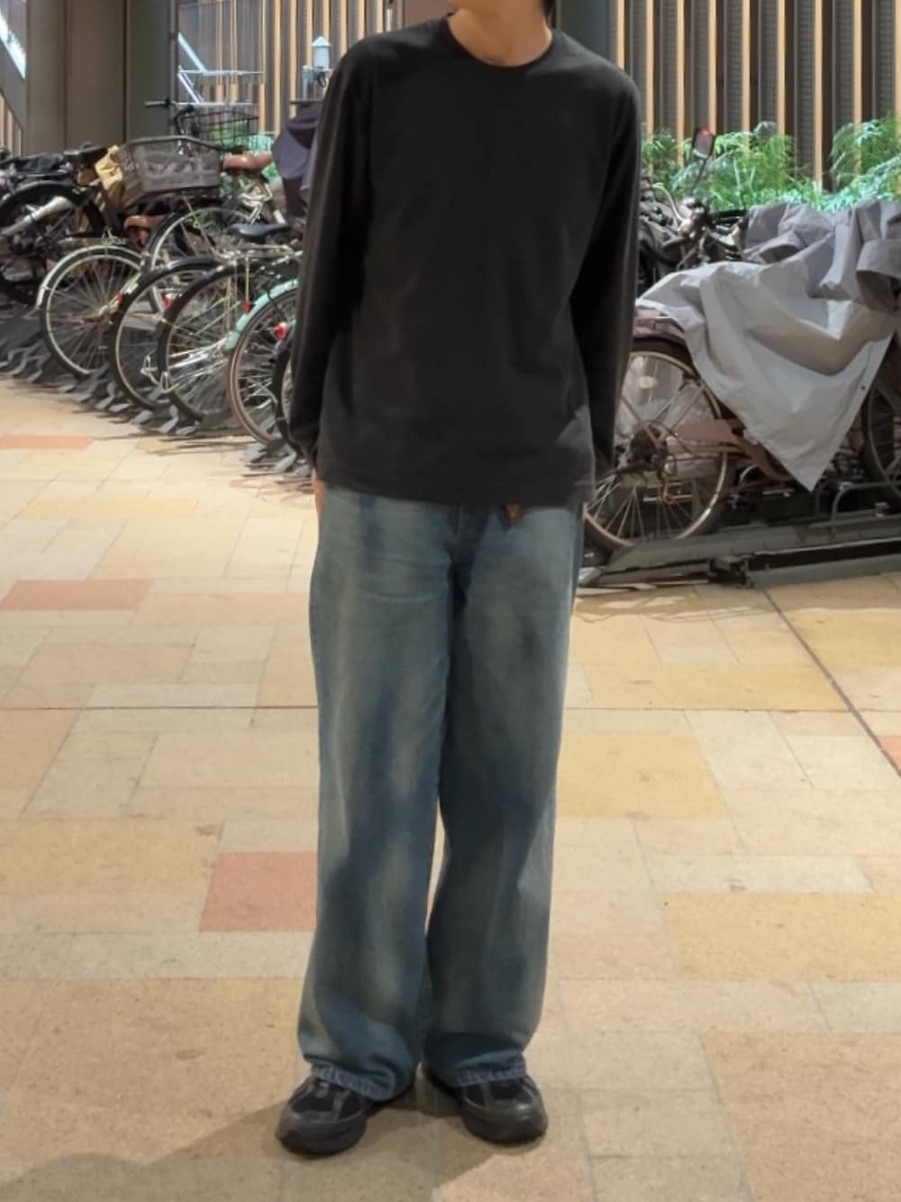 ブラック系のTシャツ/カットソー、ブルー系のデニムパンツ、ブラック系のスニーカーを着用したメンズの秋コーディネートの2枚目の写真