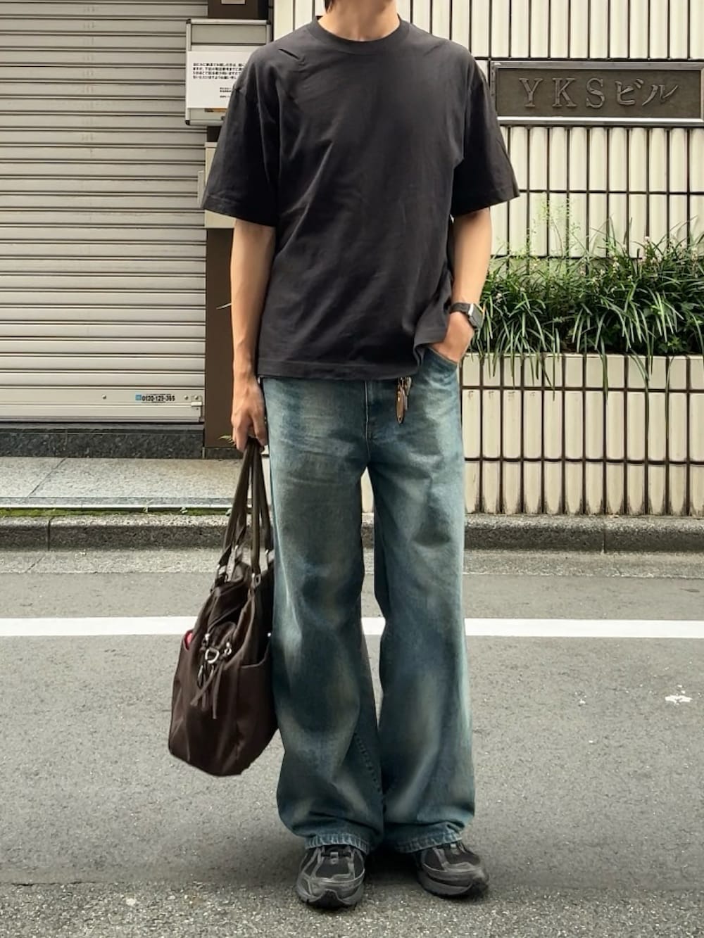ブラック系のTシャツ/カットソー、ブルー系のデニムパンツ、ブラック系のスニーカーを着用したメンズの夏コーディネートの2枚目の写真
