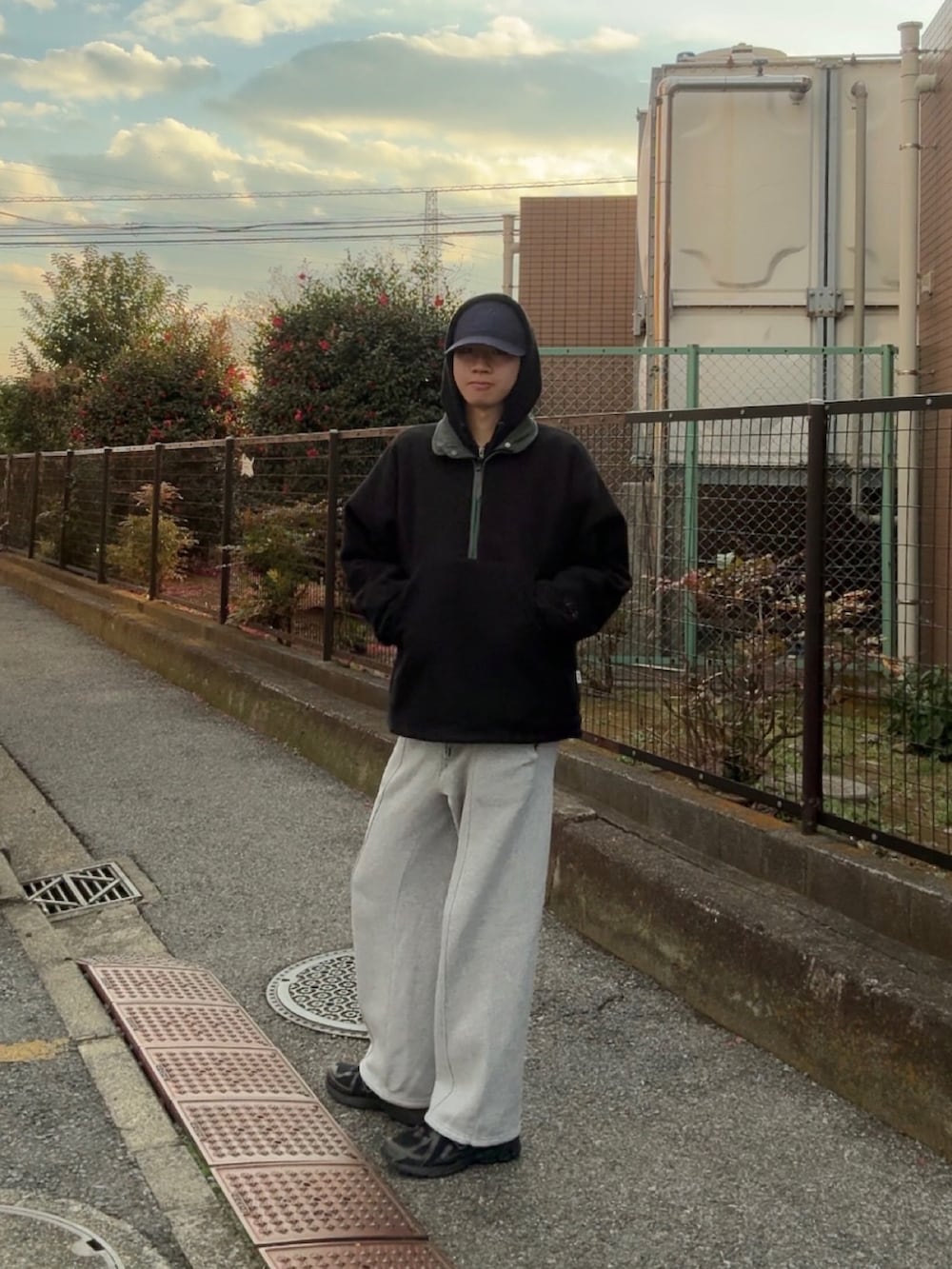 グリーン系のブルゾン、グレー系のスウェットパンツ、ブラック系のスニーカーを着用したメンズの冬コーディネートの2枚目の写真