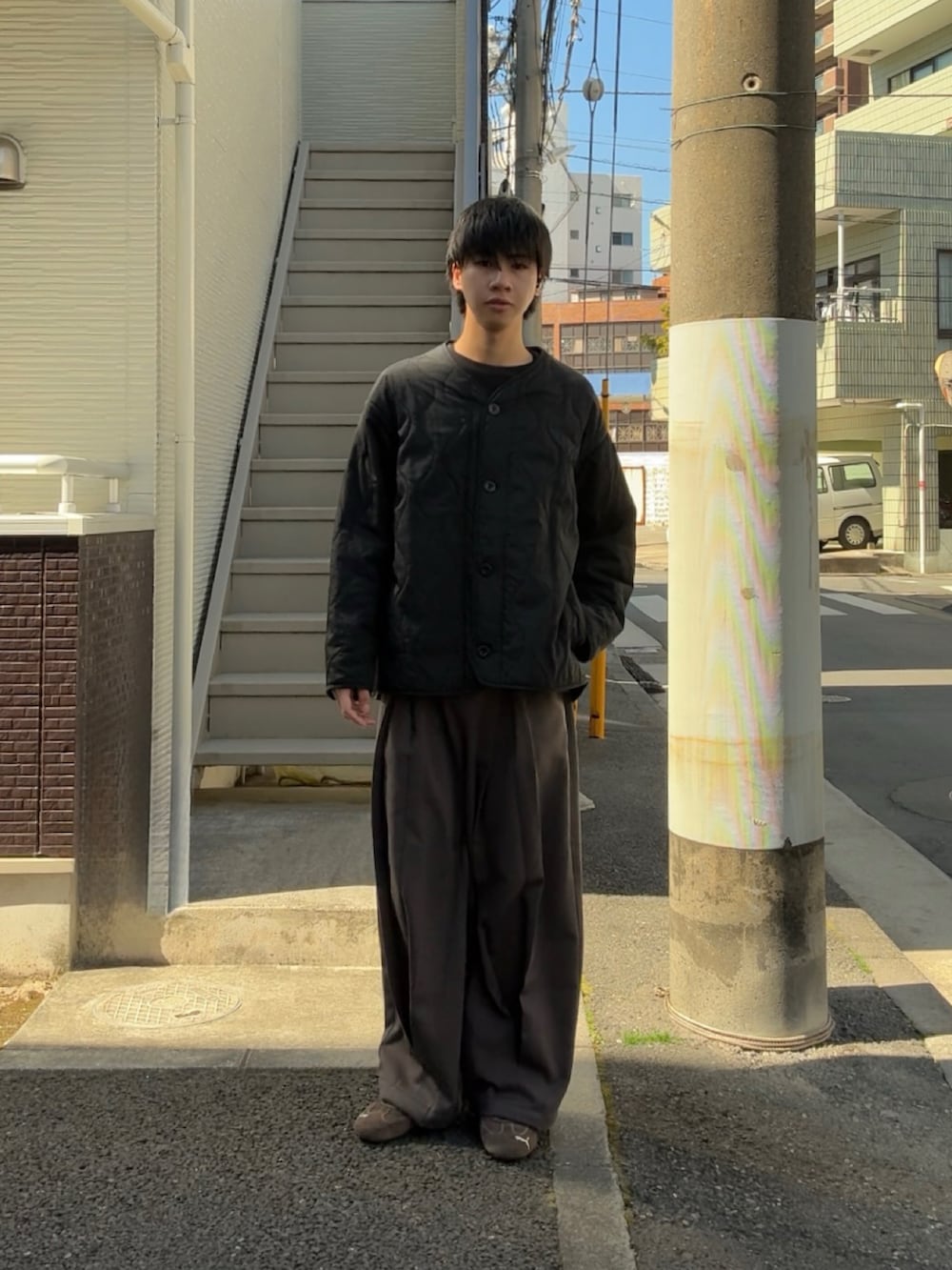 ブラック系のブルゾン、グレー系のスラックス、ブラウン系のスニーカーを着用したメンズの春コーディネートの2枚目の写真