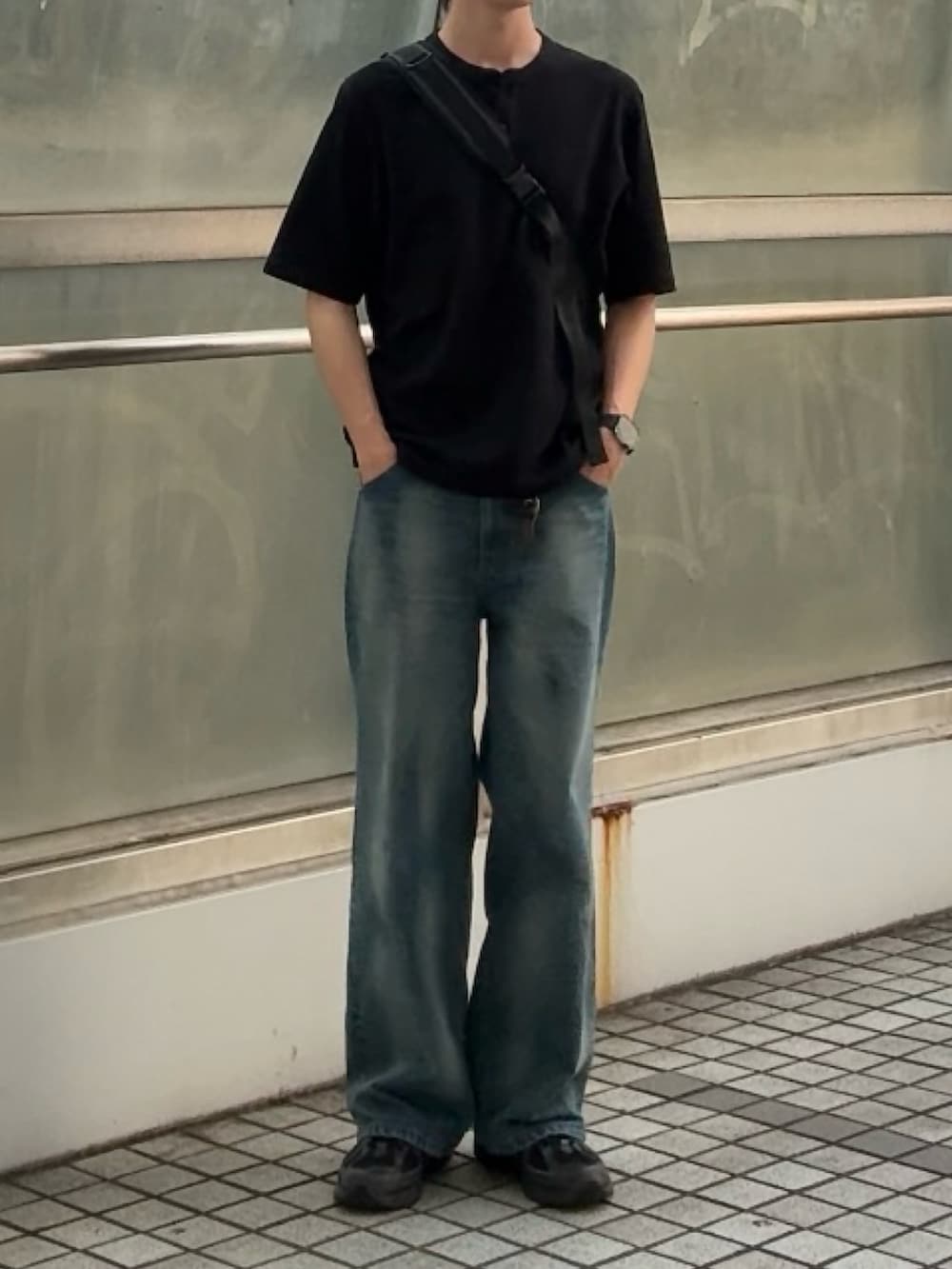 ブルー系のデニムパンツ、ブラック系のTシャツ/カットソー、ブラック系のボディバッグ/ウエストポーチを着用したメンズの夏コーディネートの2枚目の写真