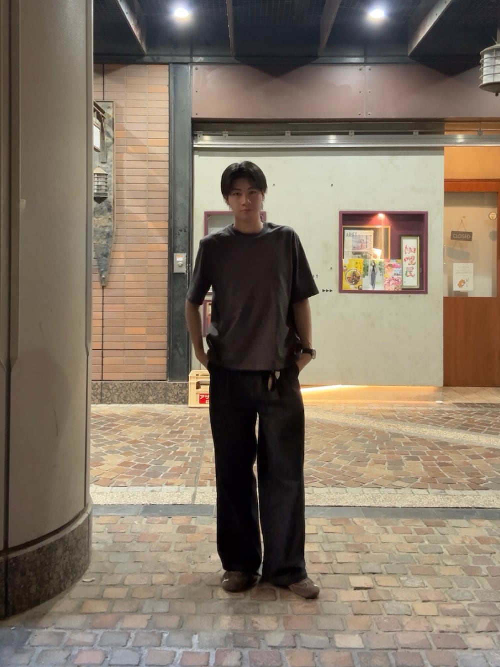 グレー系のTシャツ/カットソー、ブラック系のデニムパンツ、ブラウン系のスニーカーを着用したメンズの春コーディネートの2枚目の写真