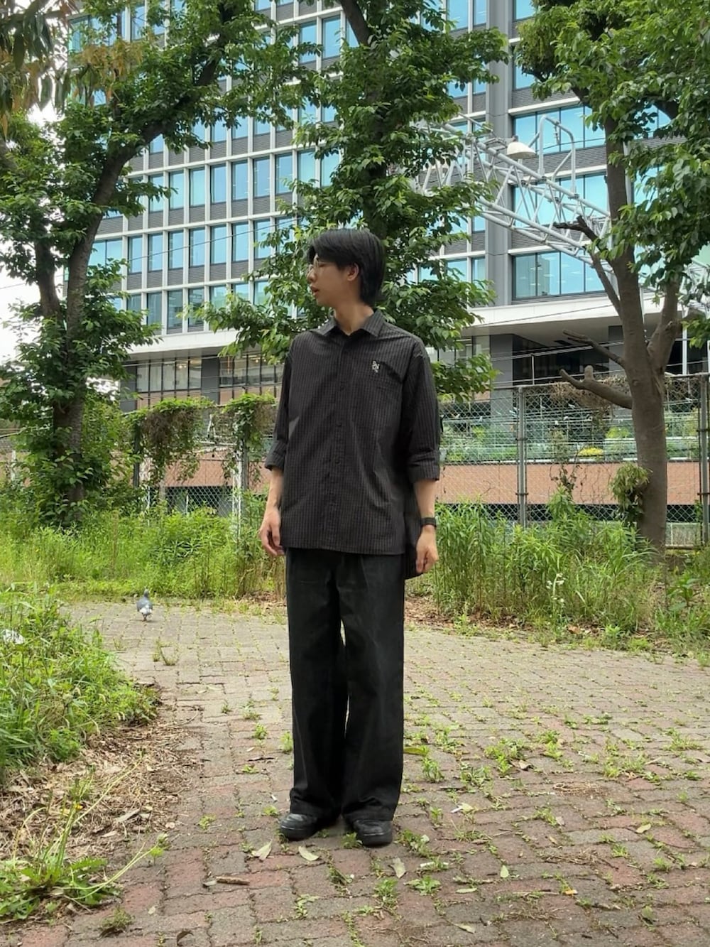 ブラック系のシャツ/ブラウス、ブラック系のデニムパンツ、ブラック系のスニーカーを着用したメンズの春コーディネートの2枚目の写真