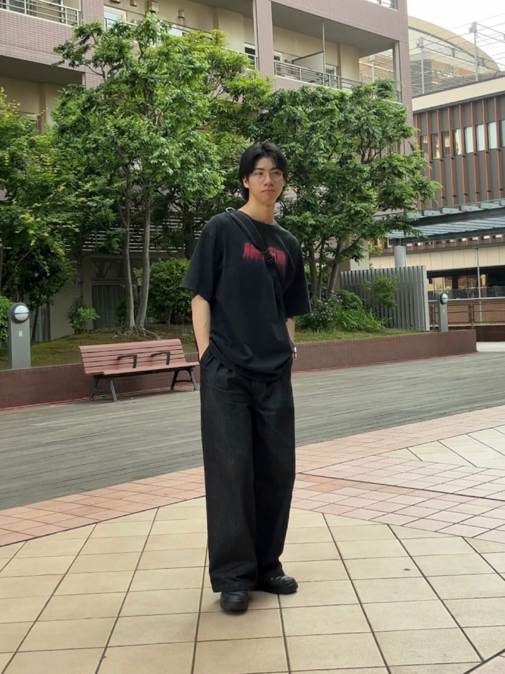 ブラック系のTシャツ/カットソー、ブラック系のデニムパンツ、ブラック系のスニーカーを着用したメンズの春コーディネートの2枚目の写真