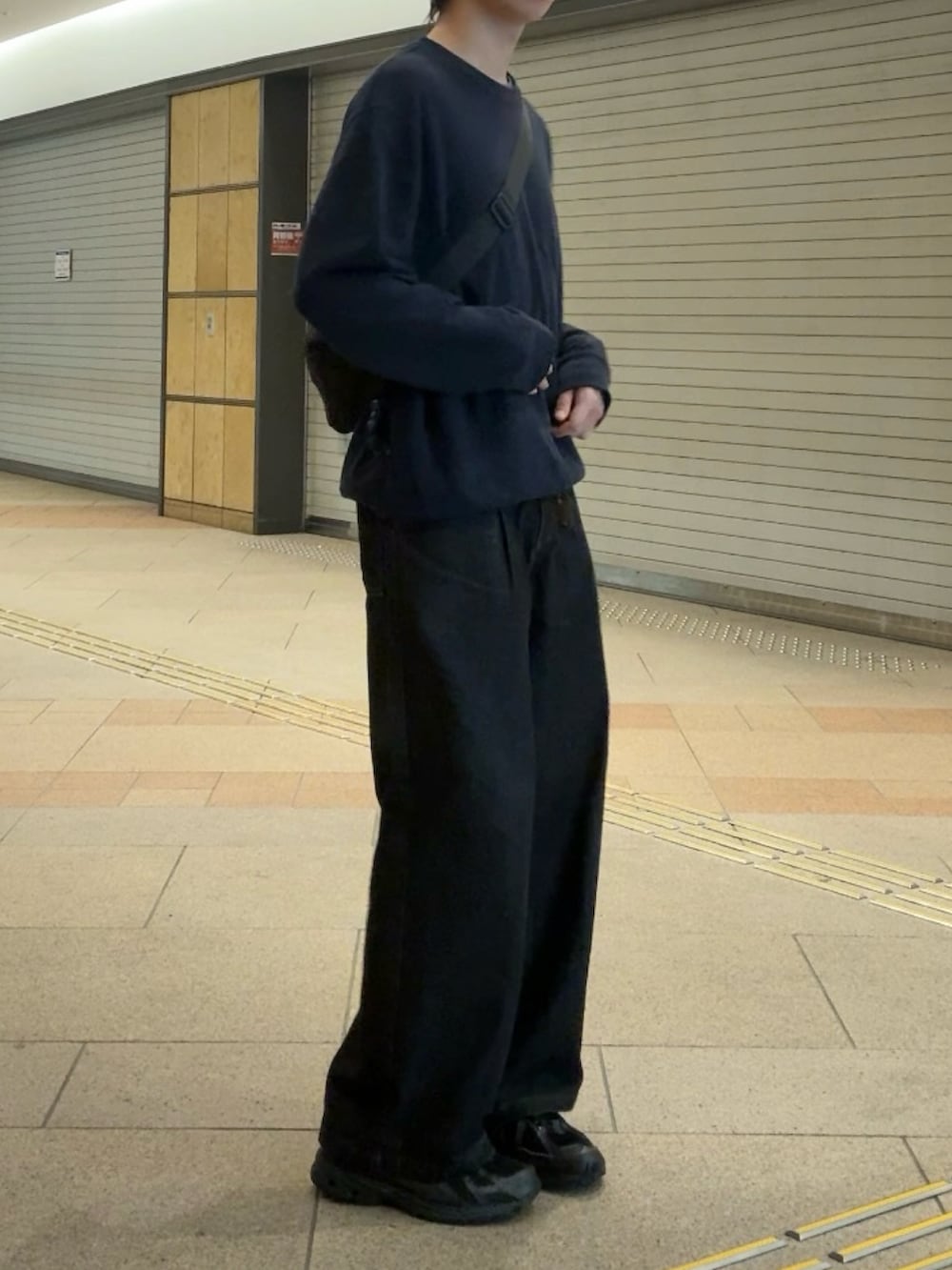 ブラック系のスウェット、ブラック系のデニムパンツ、ブラック系のスニーカーを着用したメンズの秋コーディネートの2枚目の写真