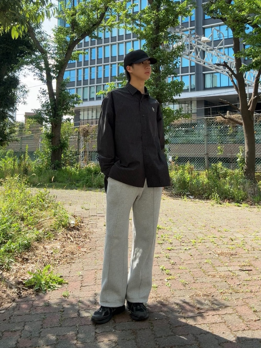 ブラック系のシャツ/ブラウス、グレー系のスウェットパンツ、ブラック系のスニーカーを着用したメンズの春コーディネートの3枚目の写真