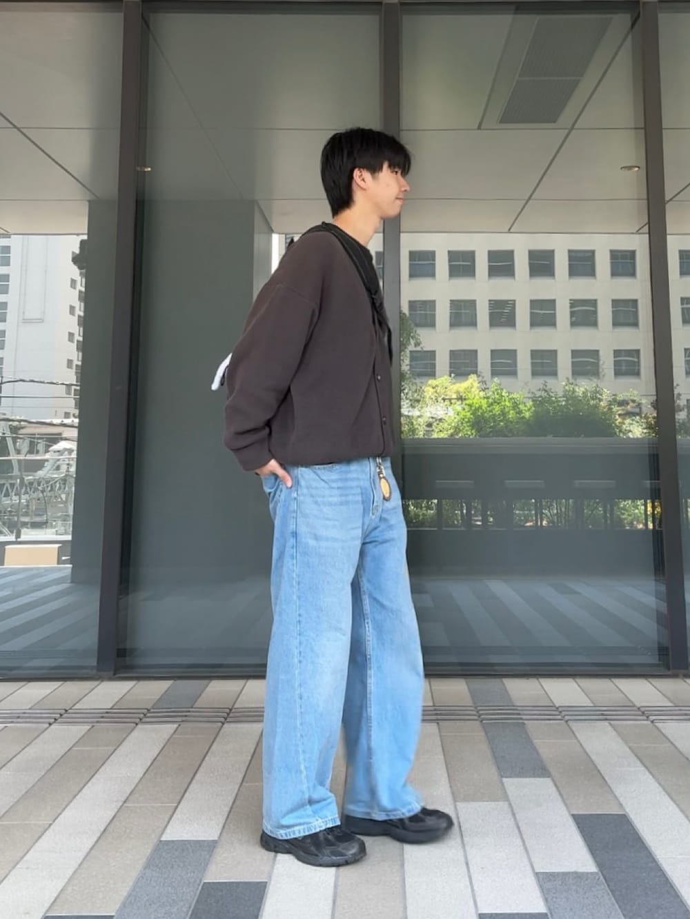 グレー系のカーディガン/ボレロ、ブラック系のスウェット、ブルー系のデニムパンツを着用したメンズの春コーディネートの2枚目の写真