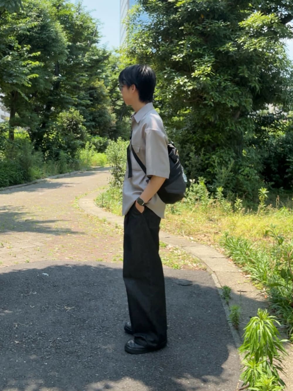 ブラック系のデニムパンツ、ベージュ系のシャツ/ブラウス、ブラック系のスニーカーを着用したメンズの夏コーディネートの2枚目の写真
