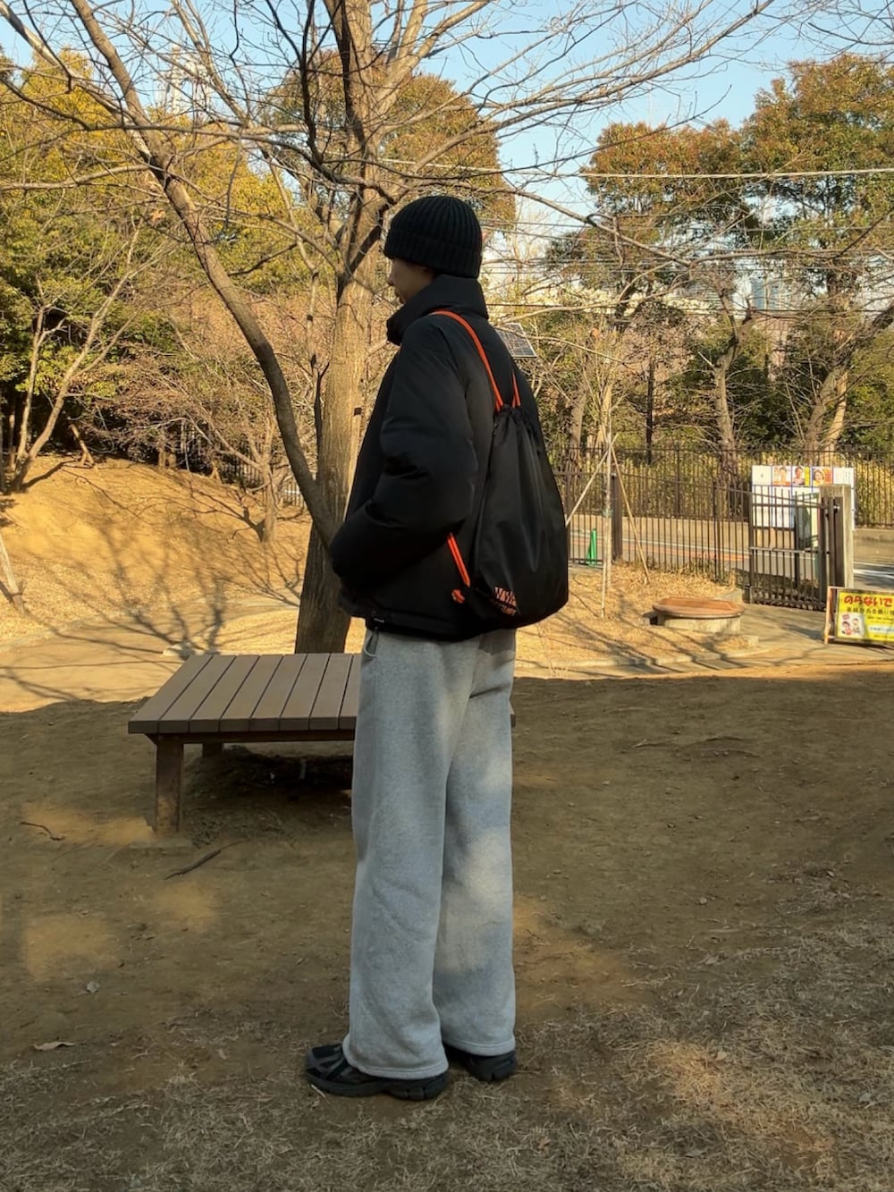 グレー系のダウンジャケット/コート、ブラック系のバックパック/リュック、グレー系のスウェットパンツを着用したメンズの冬コーディネートの2枚目の写真