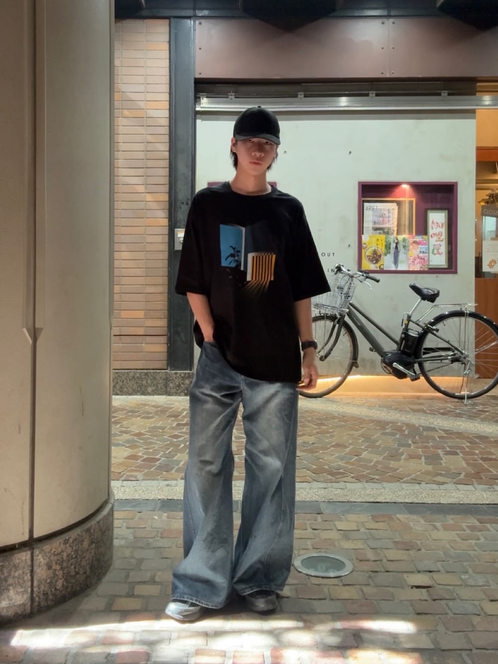 ブラック系のTシャツ/カットソー、ブルー系のデニムパンツ、ブラック系のスニーカーを着用したメンズの春コーディネートの2枚目の写真
