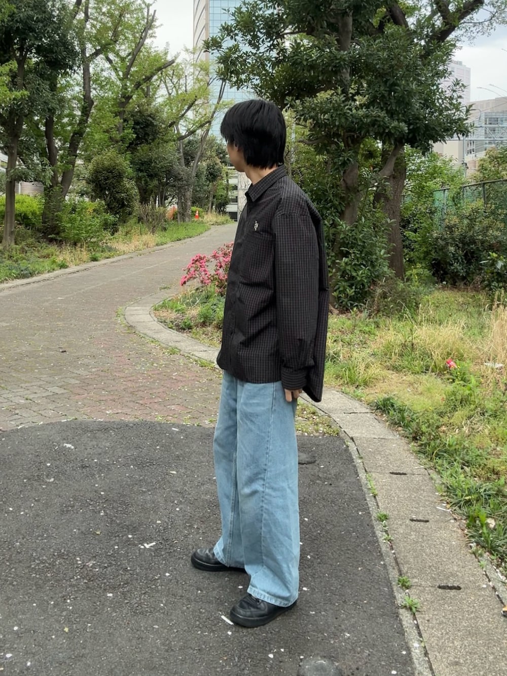 ブラック系のシャツ/ブラウス、ブルー系のデニムパンツ、ブラック系のスニーカーを着用したメンズの春コーディネートの2枚目の写真
