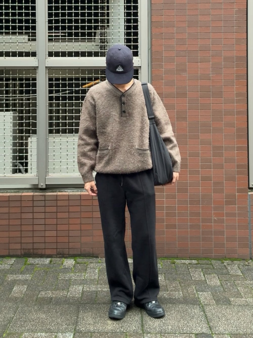 ブラウン系のニット/セーター、ブラック系のスウェットパンツ、ブラック系のスニーカーを着用したメンズの秋コーディネートの2枚目の写真