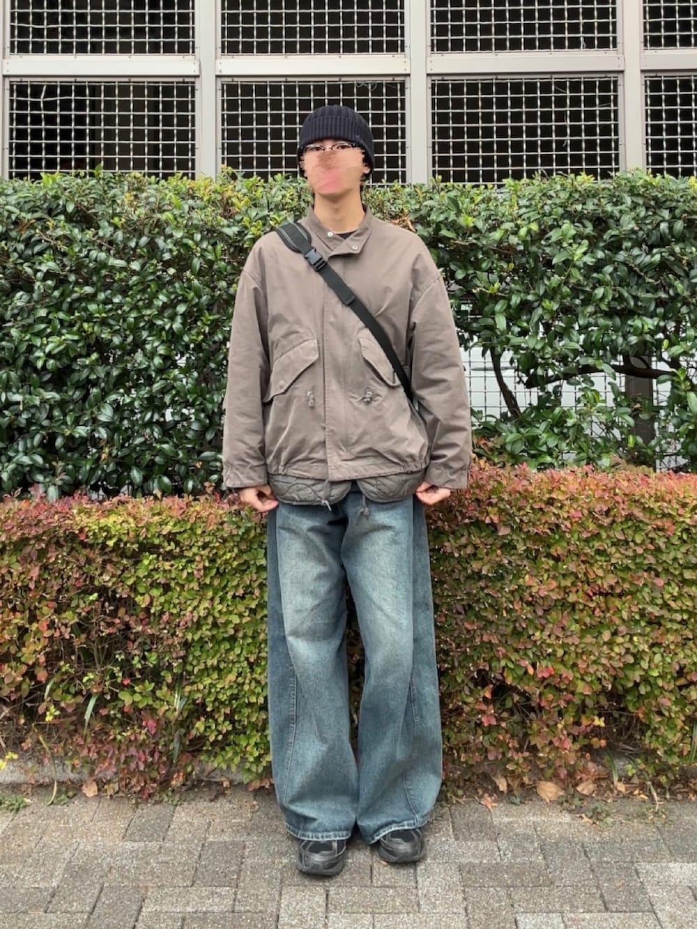 ブルー系のデニムパンツ、グリーン系のモッズコート、ブラック系のスニーカーを着用したメンズの冬コーディネートの3枚目の写真