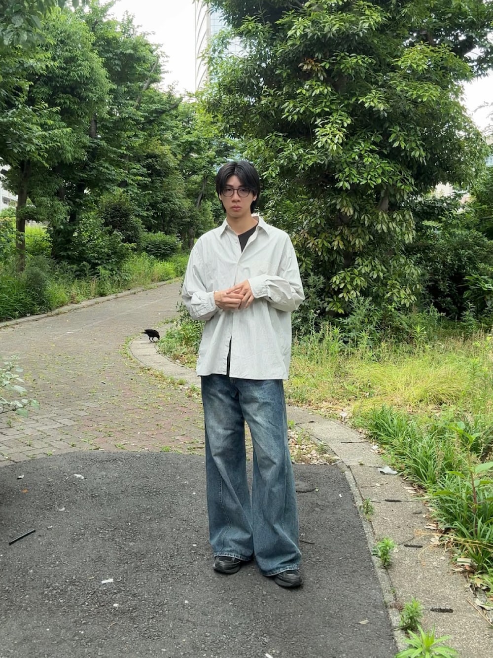 ホワイト系のシャツ/ブラウス、ブルー系のデニムパンツ、ブラック系のスニーカーを着用したメンズの春コーディネートの2枚目の写真