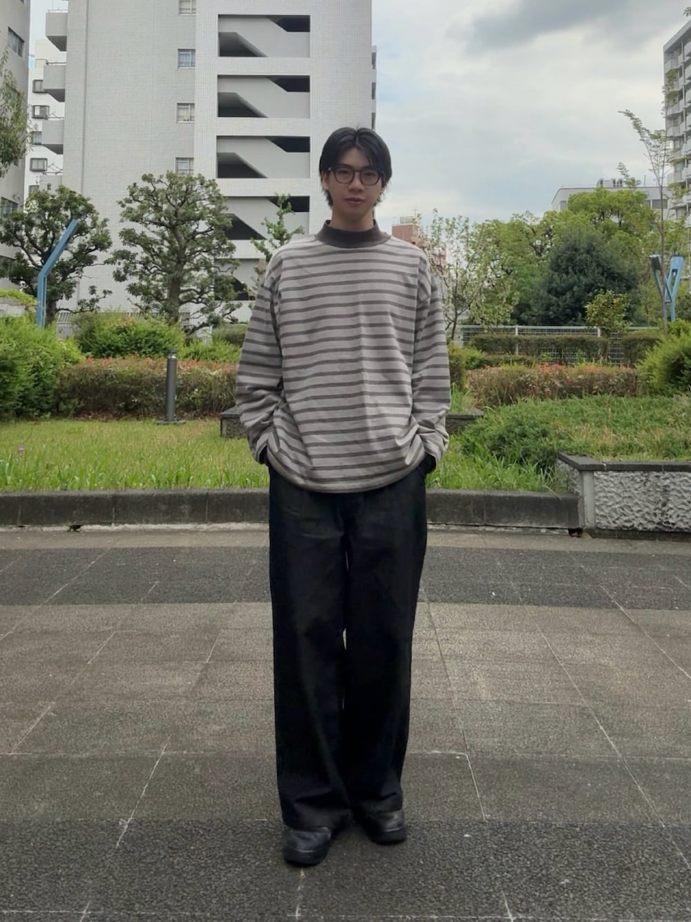 グレー系のTシャツ/カットソー、ブラック系のデニムパンツ、ブラック系のスニーカーを着用したメンズの春コーディネートの2枚目の写真