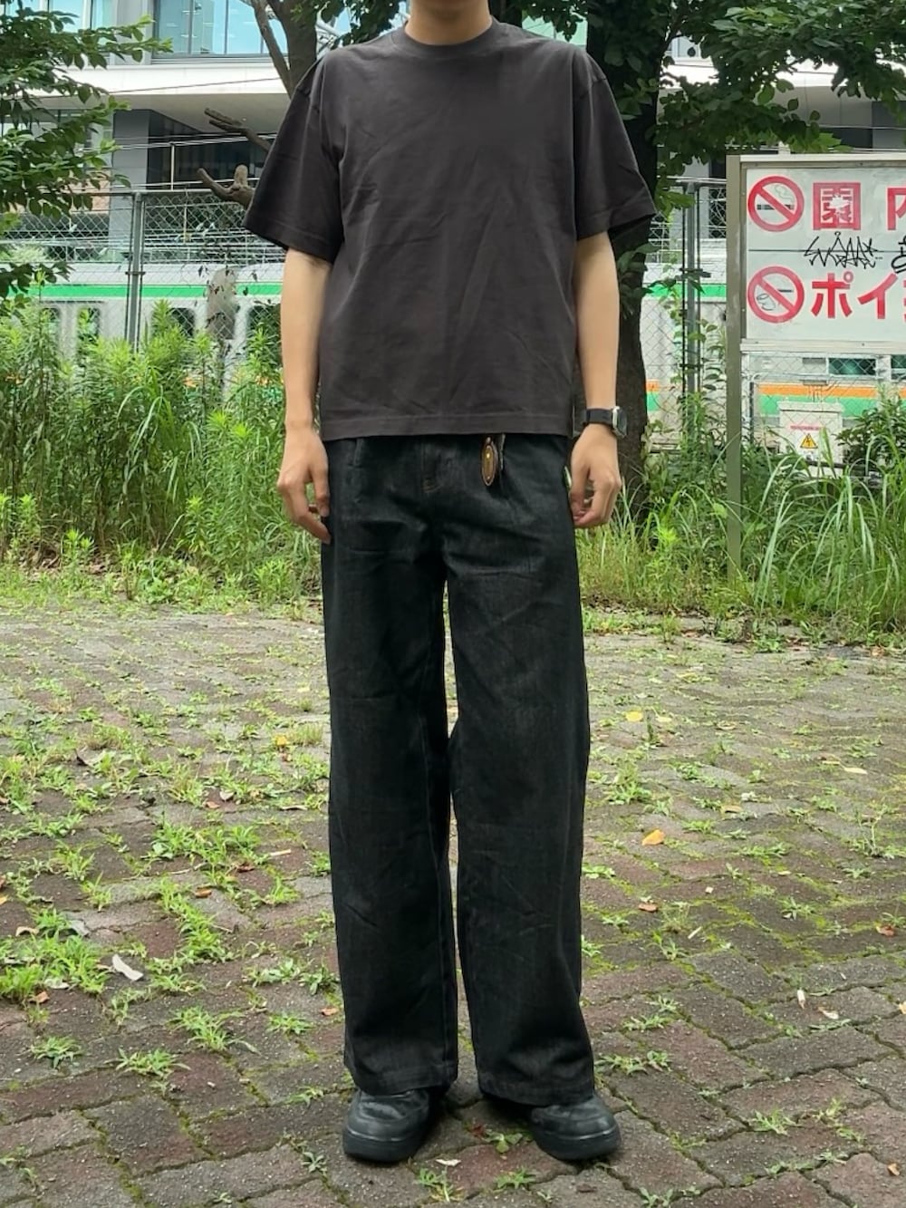 ブラック系のデニムパンツ、ブラック系のスニーカー、グレー系のTシャツ/カットソーを着用したメンズの夏コーディネートの2枚目の写真