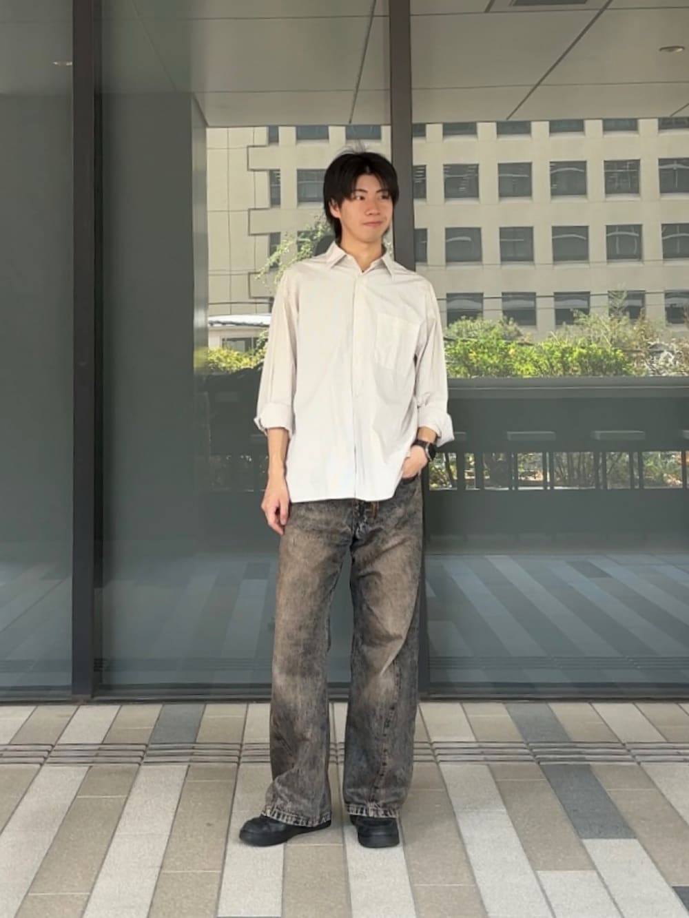 ホワイト系のシャツ/ブラウス、ブラック系のスニーカー、ブルー系のデニムパンツを着用したメンズの春コーディネートの2枚目の写真