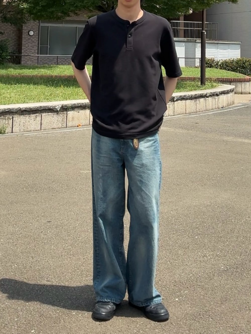 ブラック系のTシャツ/カットソー、ブルー系のデニムパンツ、ブラック系のスニーカーを着用したメンズの夏コーディネートの2枚目の写真