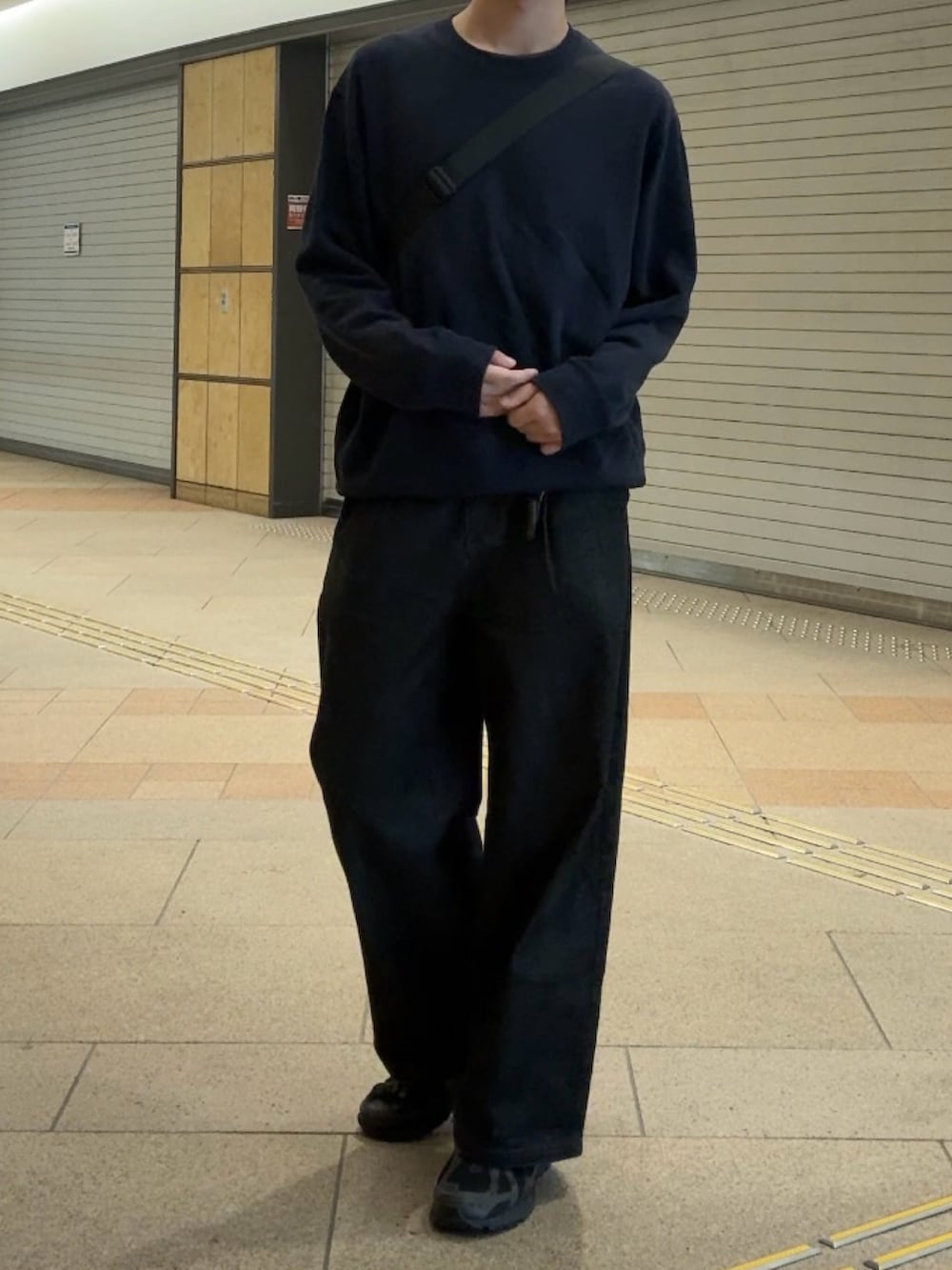 ブラック系のスウェット、ブラック系のデニムパンツ、ブラック系のスニーカーを着用したメンズの秋コーディネートの3枚目の写真