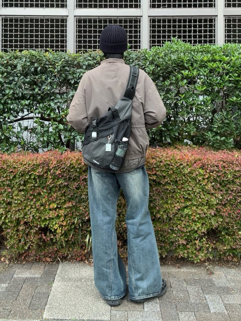 ブルー系のデニムパンツ、グリーン系のモッズコート、ブラック系のスニーカーを着用したメンズの冬コーディネートの2枚目の写真