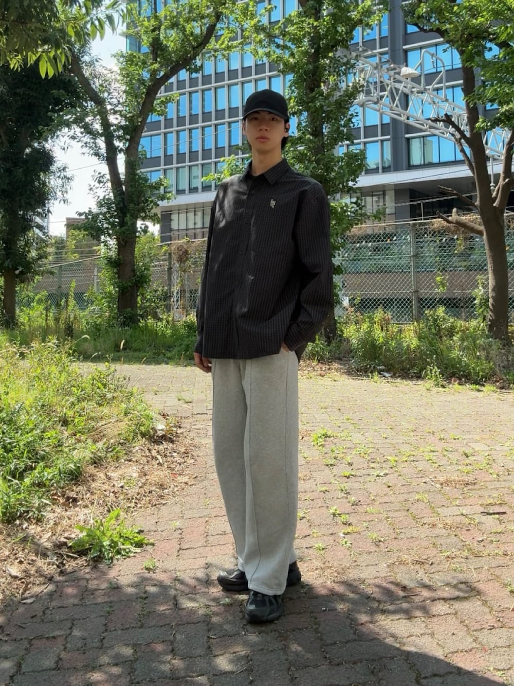 ブラック系のシャツ/ブラウス、グレー系のスウェットパンツ、ブラック系のスニーカーを着用したメンズの春コーディネートの2枚目の写真