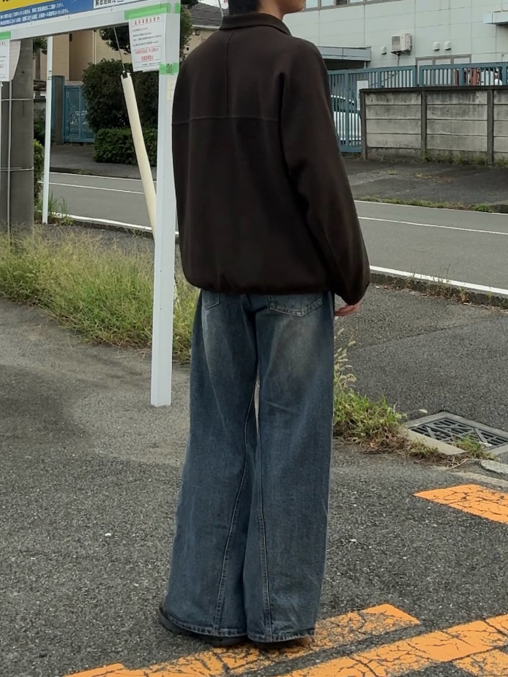 ブルー系のデニムパンツ、グレー系のTシャツ/カットソー、ブラウン系のブルゾンを着用したメンズの秋コーディネートの2枚目の写真