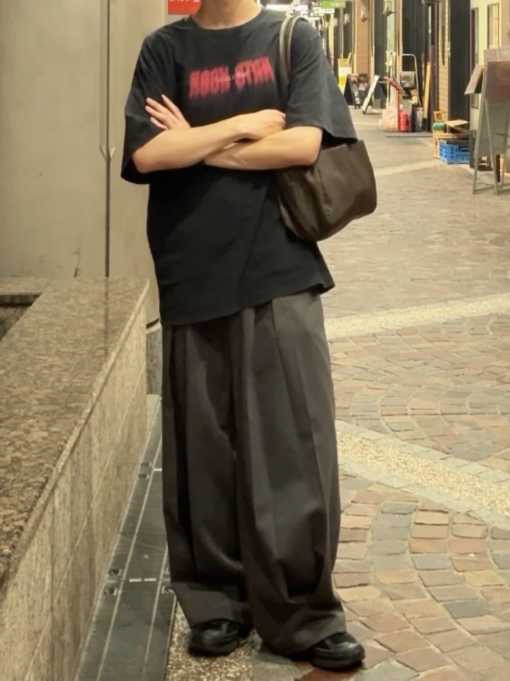 ブラック系のTシャツ/カットソー、グレー系のスラックス、ブラック系のスニーカーを着用したメンズの夏コーディネートの2枚目の写真