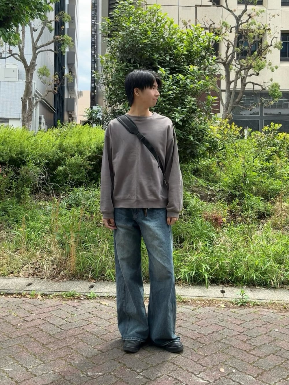グレー系のスウェット、ブルー系のデニムパンツ、ブラック系のボディバッグ/ウエストポーチを着用したメンズの春コーディネートの3枚目の写真